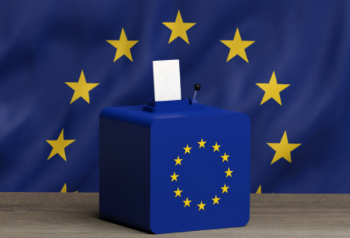 Europaflagge im Hintergrund und auf der Wahlurne