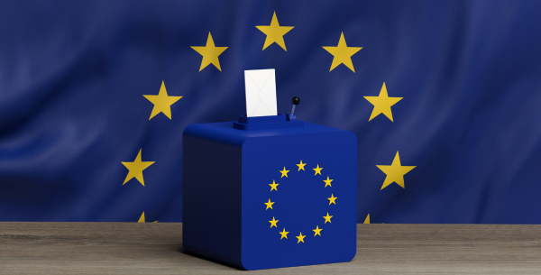 Europaflagge im Hintergrund und auf der Wahlurne